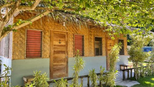 ein Backsteinhaus mit Holztüren und Fenstern in der Unterkunft Sabas Beach and Campsite in Siquijor