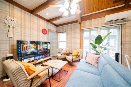 a living room with a blue couch and a tv at ふくの宿 in Kamegawa