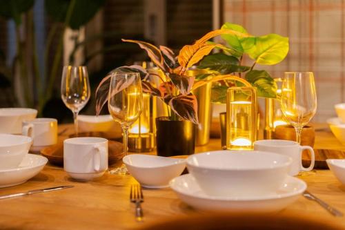 a wooden table with white dishes and glasses on it at ふくの宿 in Kamegawa