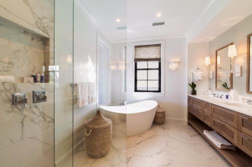 a bathroom with a tub and a glass shower at Grace Bay Club in Grace Bay