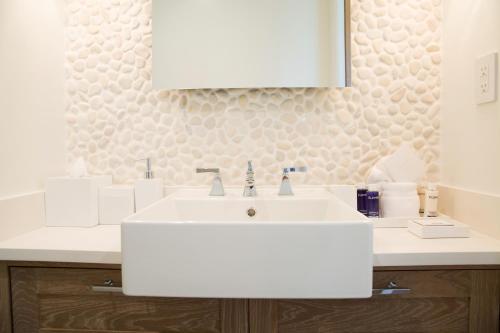a bathroom with a white sink and a mirror at Grace Bay Club in Grace Bay