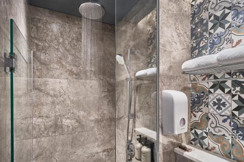 W łazience znajduje się prysznic ze szklanymi drzwiami. w obiekcie Mercure ICON Singapore City Centre w Singapurze