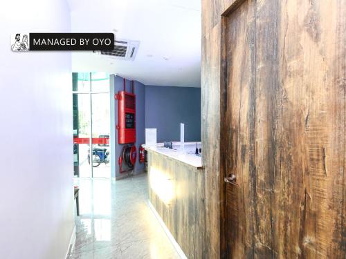 Super OYO GS Hotels Near Strand Mall في كوتا دامانسارا: مدخل مع جدار خشبي في الغرفة