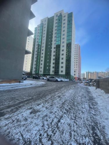 a snow covered street in front of tall buildings at Middle River Apartment & Tours in Ulaanbaatar
