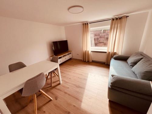 sala de estar con sofá, mesa y TV en Ferienwohnung/Monteurwohnung Souterrain, neu renoviert, en Minden