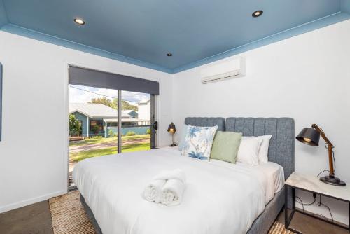 a bedroom with a large bed with a blue ceiling at Woodlands Sunsets Soldiers Point - Whole Property in Soldiers Point