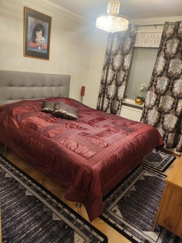 1 dormitorio con 1 cama con edredón rojo en Ananis Stuga, en Svartå