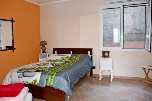 ein Schlafzimmer mit einem Bett und zwei Fenstern in der Unterkunft CASA RINA in Ventimiglia