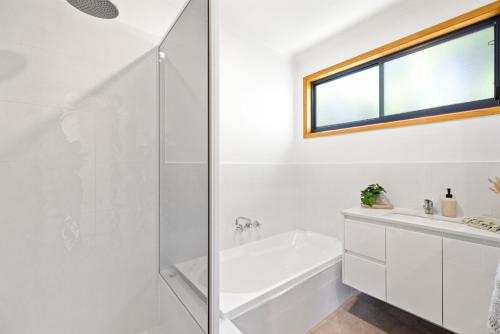 a white bathroom with a tub and a sink at Sunset Escape in Sunset Strip