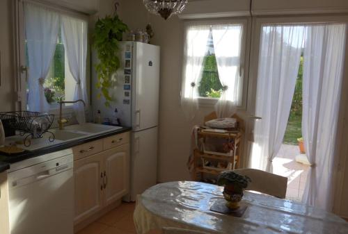 a kitchen with a white refrigerator and a table at The Flower- Townhouse with air conditioning and garden! in Montpellier