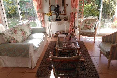 een woonkamer met een bank en een tafel bij The Flower- Townhouse with air conditioning and garden! in Montpellier