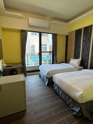 a hotel room with two beds and a balcony at Black Diamond Hotel in Xiaoliuqiu