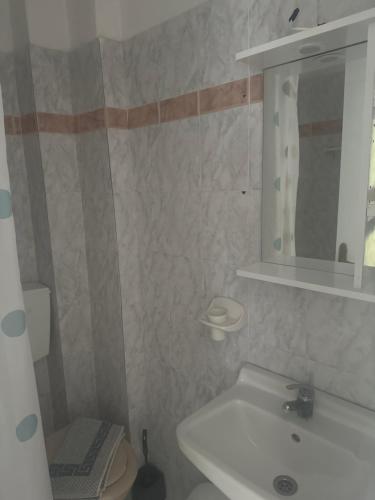 a bathroom with a sink and a toilet and a mirror at Pansion Angela in Skiathos Town