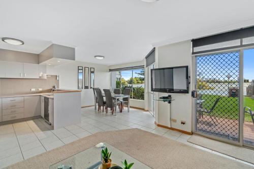 an open kitchen and living room with sliding glass doors at Yarrawonga Lakeside Apartment 49 in Mulwala
