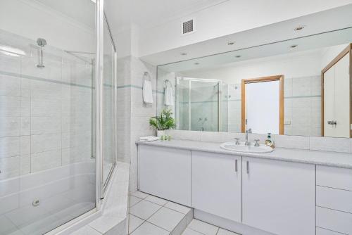 a white bathroom with a sink and a shower at Yarrawonga Lakeside Apartment 49 in Mulwala