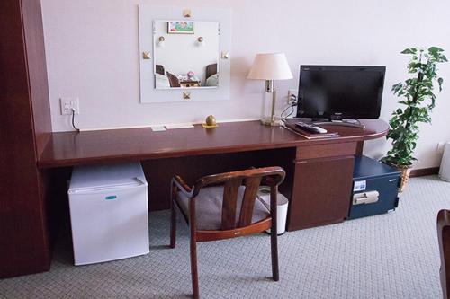 都城的住宿－ホテル中山荘，一张桌子,一张桌子,一台电脑和一把椅子放在一个房间里