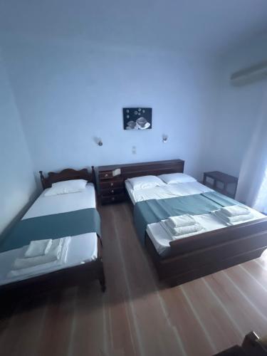 two beds in a room with blue lighting at Pansion Angela in Skiathos Town