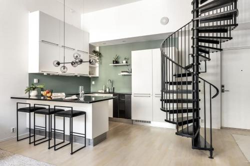 a kitchen with a black spiral staircase in a house at Stilren leilighet midt i Oslo sentrum in Oslo