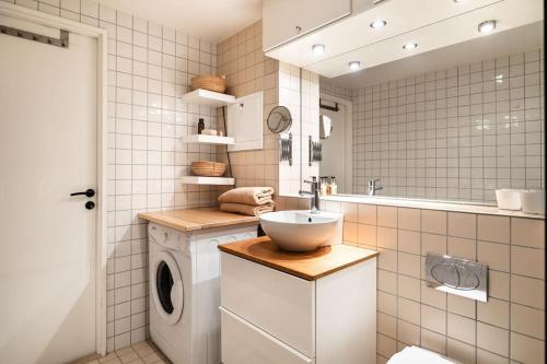 a bathroom with a sink and a washing machine at Stilren leilighet midt i Oslo sentrum in Oslo