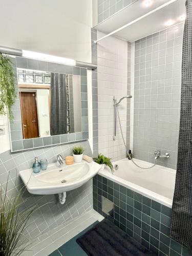 a bathroom with a sink and a tub and a mirror at JAMES BOND Apartment TOP Location Air Conditioned in Bratislava