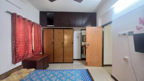 a bedroom with a bed and wooden cabinets and a door at Happy Beach House in Chennai