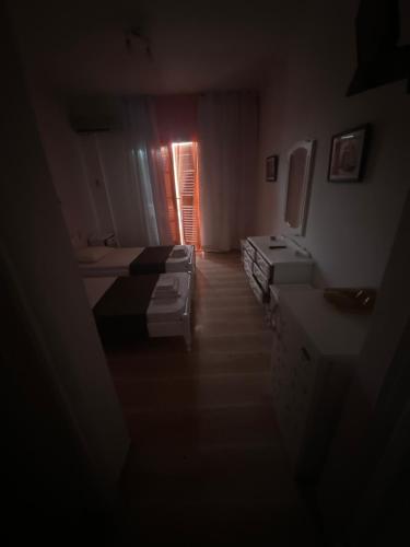 a dark room with two beds and a window at Pansion Angela in Skiathos Town