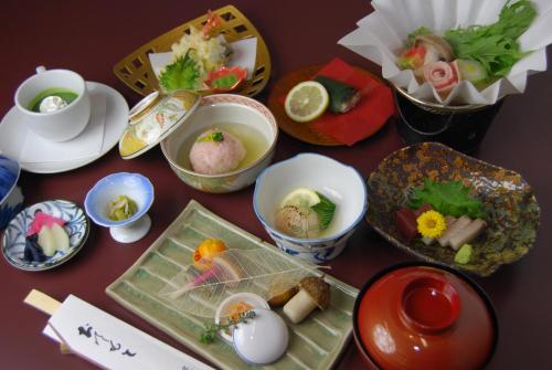 une table recouverte de bols et de assiettes de nourriture dans l'établissement Matsumoto Ryokan, à Kyoto