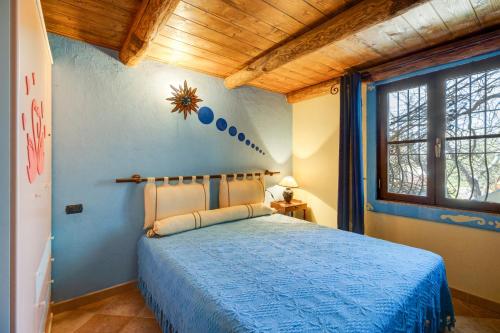 een slaapkamer met een blauw bed in een kamer bij Il rifugio di Mandriola in Putzu Idu