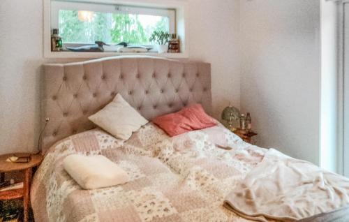 a bed with two pillows on it in a bedroom at Lovely Home In Blid With Kitchen in Blidö