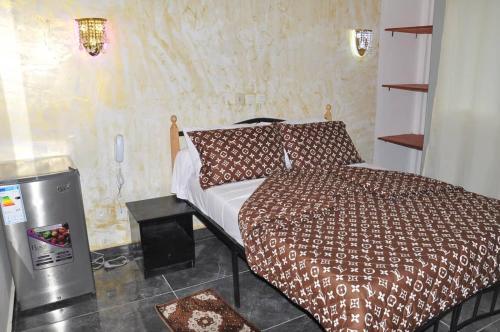 ein Schlafzimmer mit einem Bett in einem Zimmer in der Unterkunft Explorez le charme et élégance de MMEWEL HÔTEL in Douala