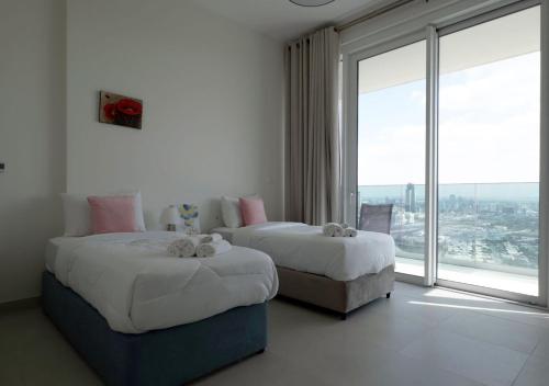 two beds in a room with a large window at Dubai Frame view, 5 mins to Burj Khalifa in Dubai