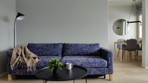 uma sala de estar com um sofá azul e uma mesa em Green Getaway - near Helsinki Vantaa Airport, top-floor, free parking & wifi em Vantaa