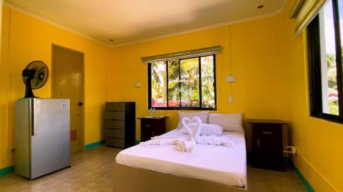sypialnia z dużym łóżkiem z białą pościelą i lodówką w obiekcie L&L Beach Resort w mieście Pandan