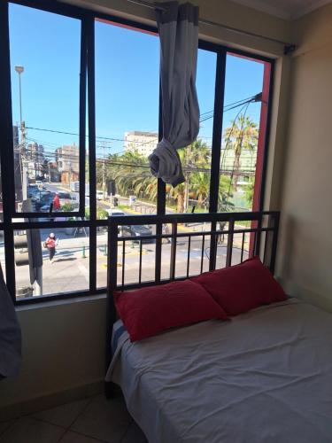 a bedroom with a bed in front of a window at Hotel San Felipe Iquique in Iquique