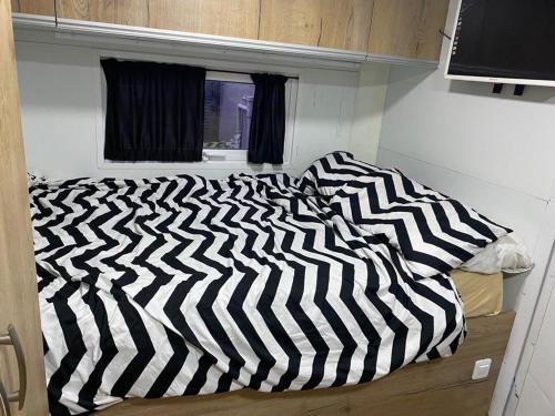 a black and white comforter on a bed in a room at קראוון ברעננה in Ra‘ananna