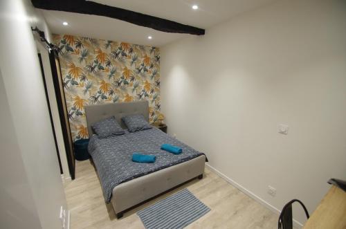 Dormitorio pequeño con cama con almohadas azules en Le Cladel - 4 pers / Proche Hopital et Eurythmie, en Montauban