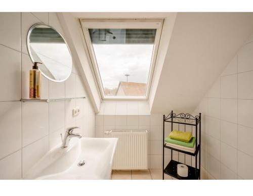 Un baño con lavabo y ventana. en Hirschen Apartments, en Oberreute