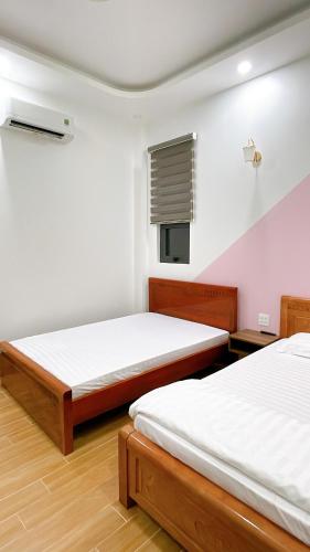 1 dormitorio con 2 camas y ventana en Nhà Nghỉ Thảo Tiên, en Xóm Tràm Cửa