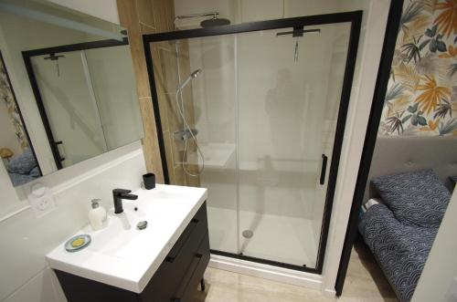y baño con ducha y lavabo blanco. en Le Cladel - 4 pers / Proche Hopital et Eurythmie, en Montauban