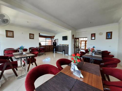 a dining room with wooden tables and red chairs at Hotel Chail Residency in Chail