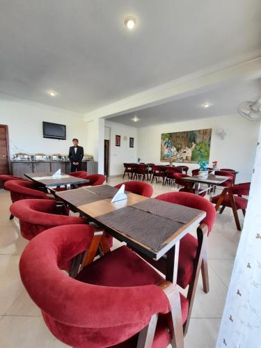 a restaurant with wooden tables and red chairs at Hotel Chail Residency in Chail