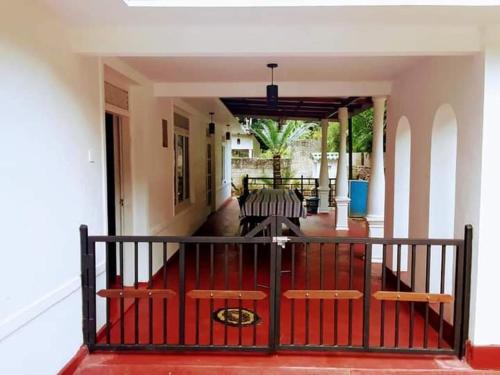 a porch with two chairs and a railing at Black And White Elkaduwa Guest House in Elkaduwa