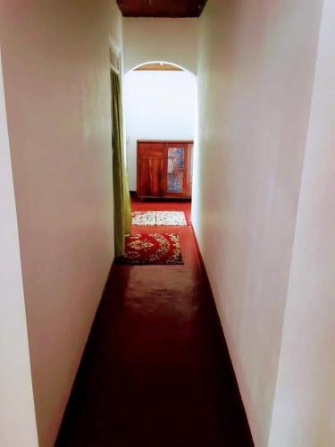 um corredor que leva a um quarto com piso vermelho em Black And White Elkaduwa Guest House em Elkaduwa