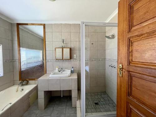 een badkamer met een bad, een wastafel en een douche bij Eagles View Kungwini in Bronkhorstspruit