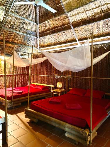 a bedroom with two beds and a hammock at Hometravel Mekong Can Tho in Can Tho