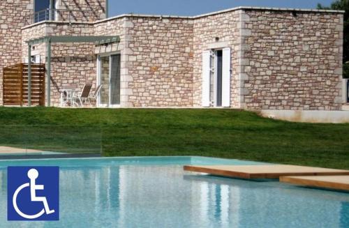 a house with a swimming pool in front of it at Stone Bay Houses in Messinia Kalamaki Beach Area in Chrani