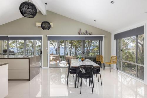 a kitchen and dining room with a table and chairs at Tree Tops Water Front Soldiers Point- First Floor in Soldiers Point