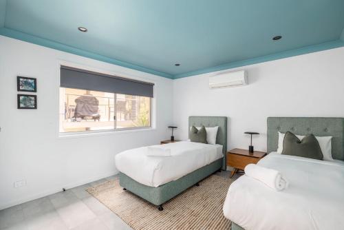 a bedroom with two beds and a window at Tree Tops Water Front Soldiers Point- First Floor in Soldiers Point