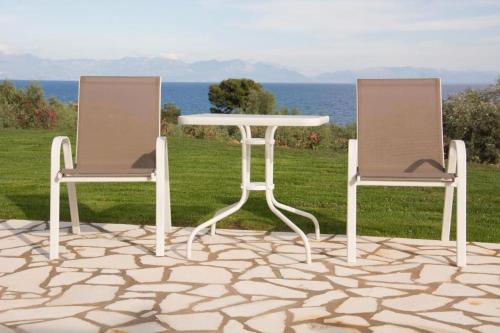 two chairs and a table and a table and chairs at Stone Bay Houses in Messinia Kalamaki Beach Area in Chrani