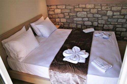 a bed with white sheets and a flower on it at Stone Bay Houses in Messinia Kalamaki Beach Area in Chrani